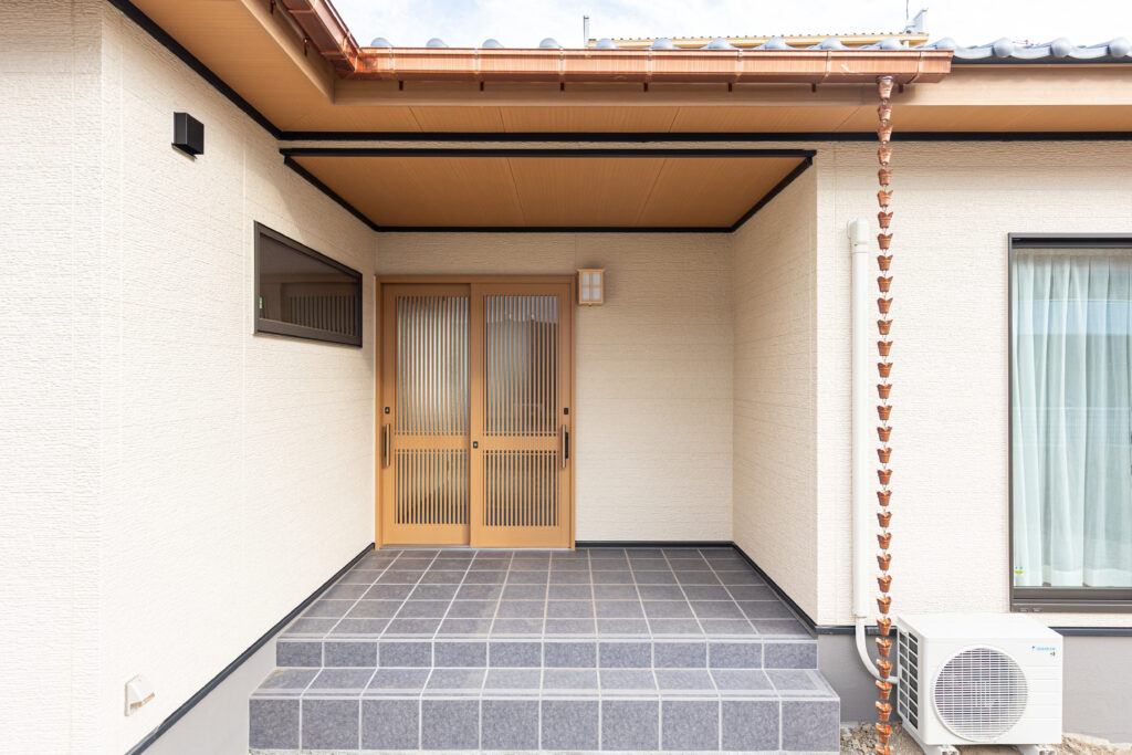 日本瓦の屋根に「くさり樋」が情緒を添える和の趣深い玄関アプローチ